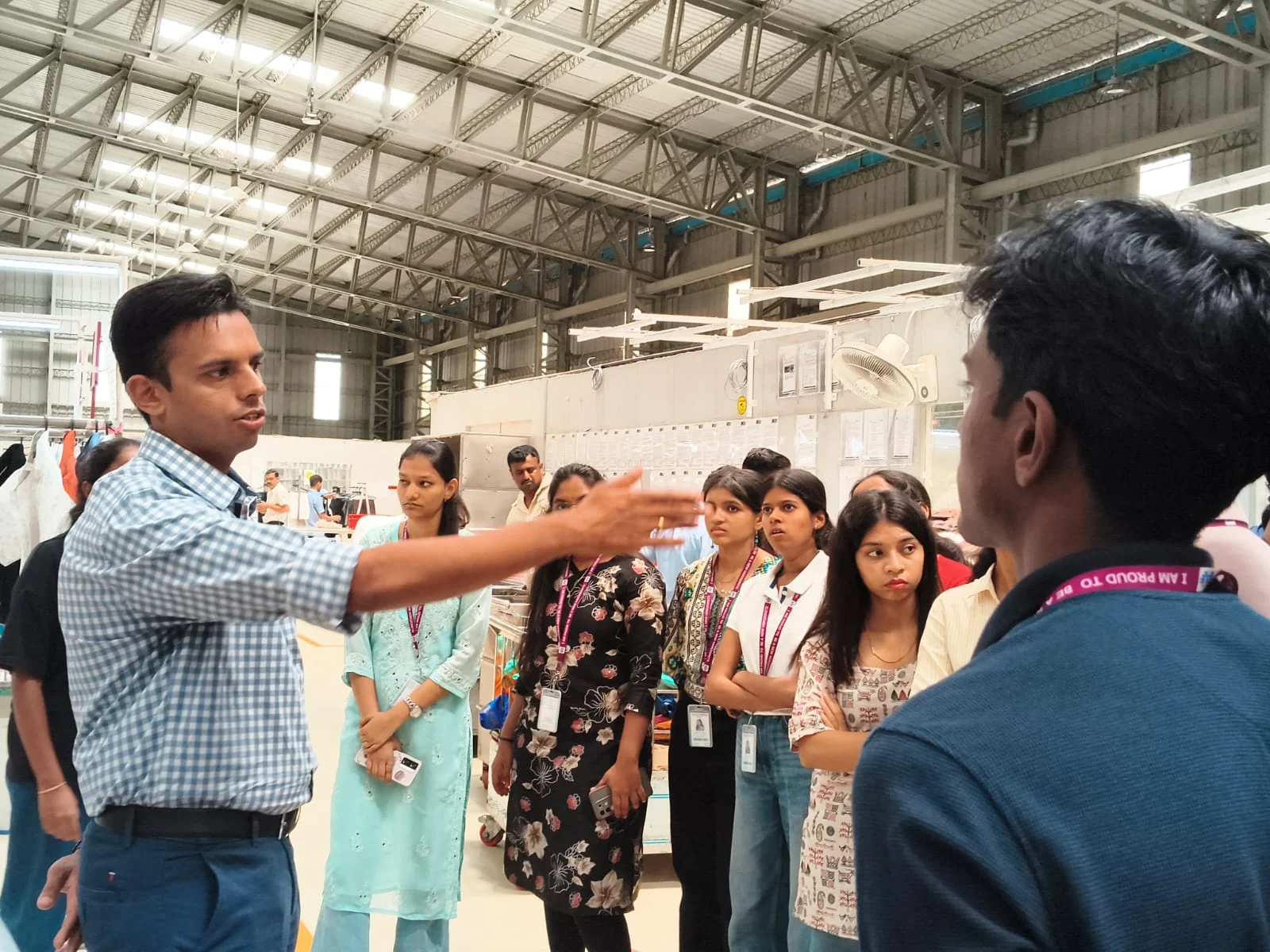 Students listening to a guide inside a working industrial facility