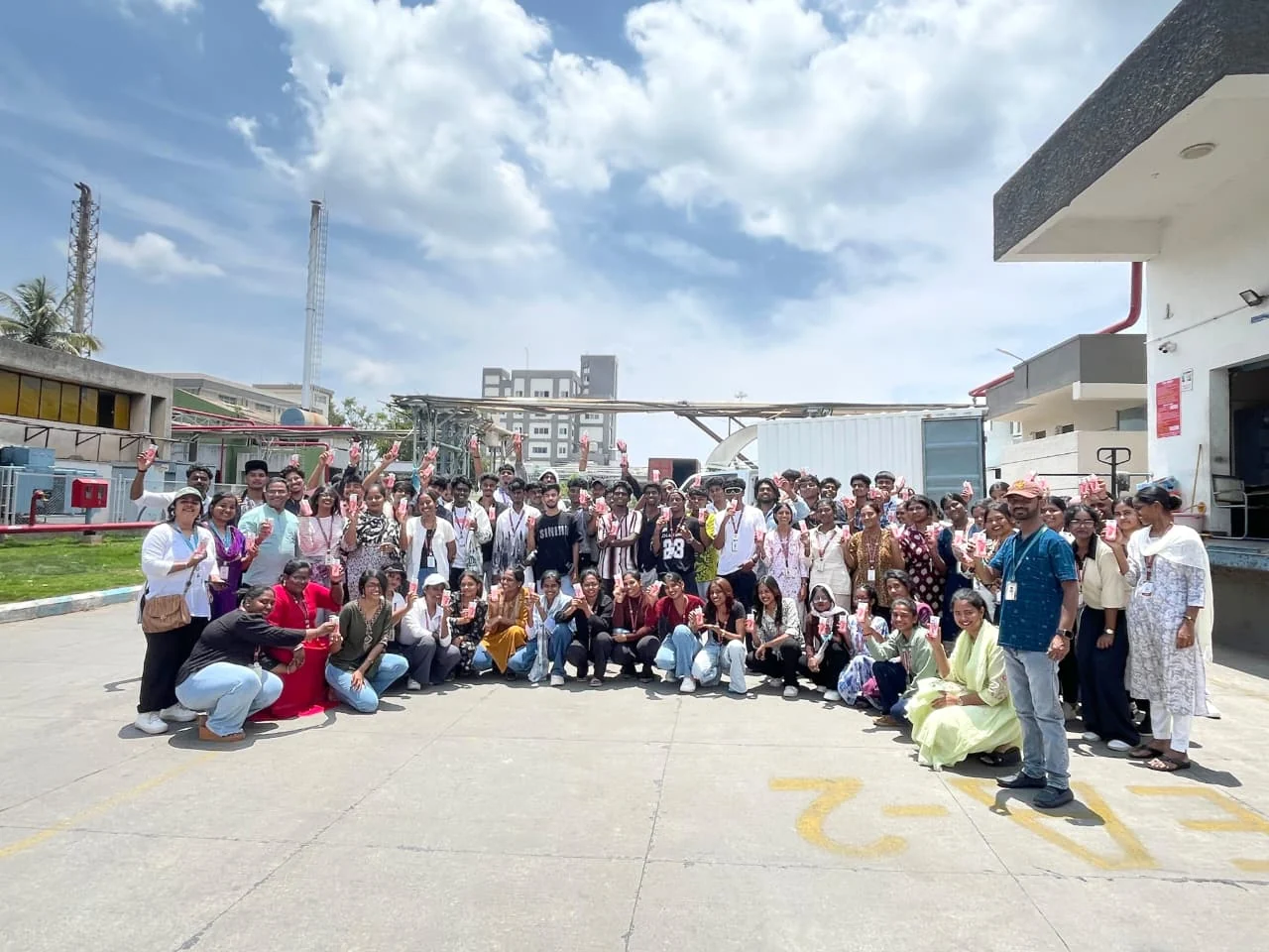 Students and educators outdoors near a facility